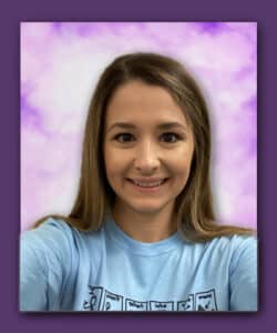 White female with long straight brown hair and a light blue tee shirt