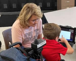 Woman working with a male student on a computer